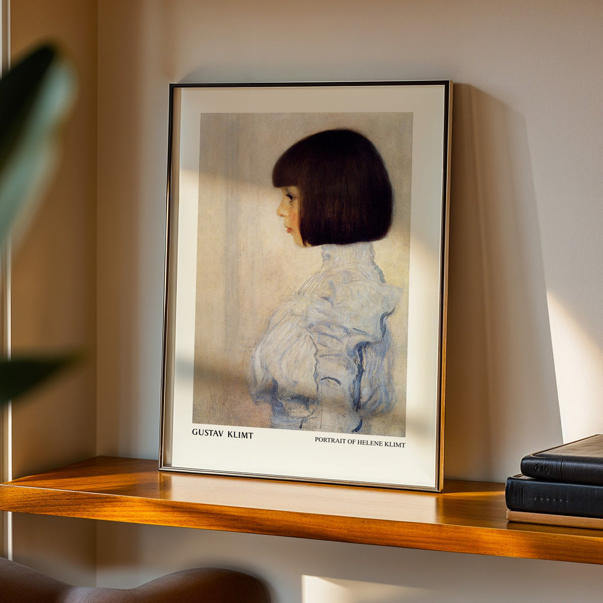 Portrait of Helene Klimt print in a black frame on a walnut shelf in evening light