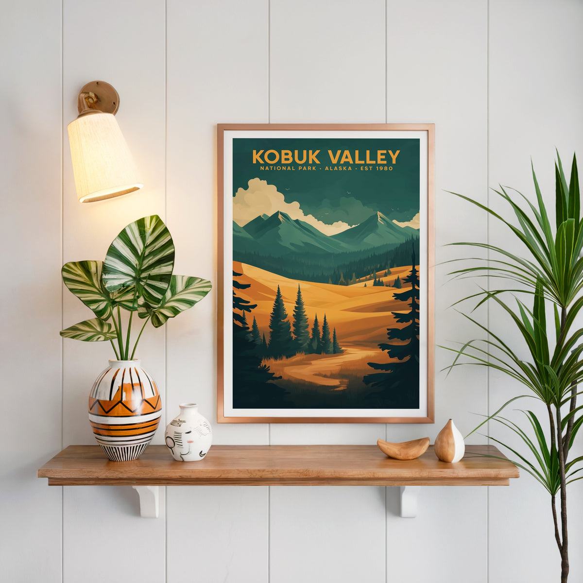 Kobuk Valley National Park print in a copper frame above an oak shelf on white shiplap with a brass sconce