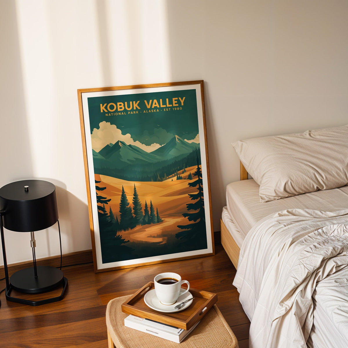 Kobuk Valley National Park print in an oak frame leaning on a bedroom floor beside the bed and a coffee tray