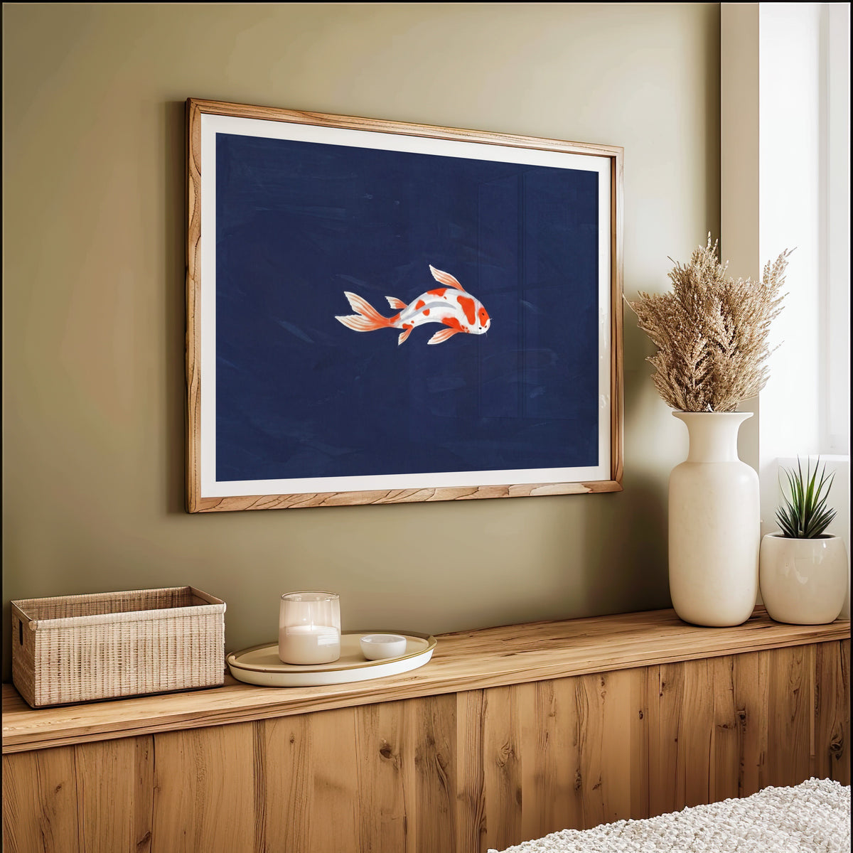 Koi fish on navy print in an oak frame on an olive green wall above pampas grass