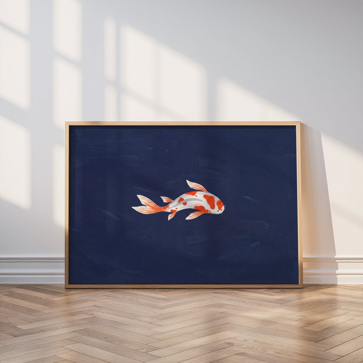 Single koi fish print in an oak frame leaning on a parquet floor in window light