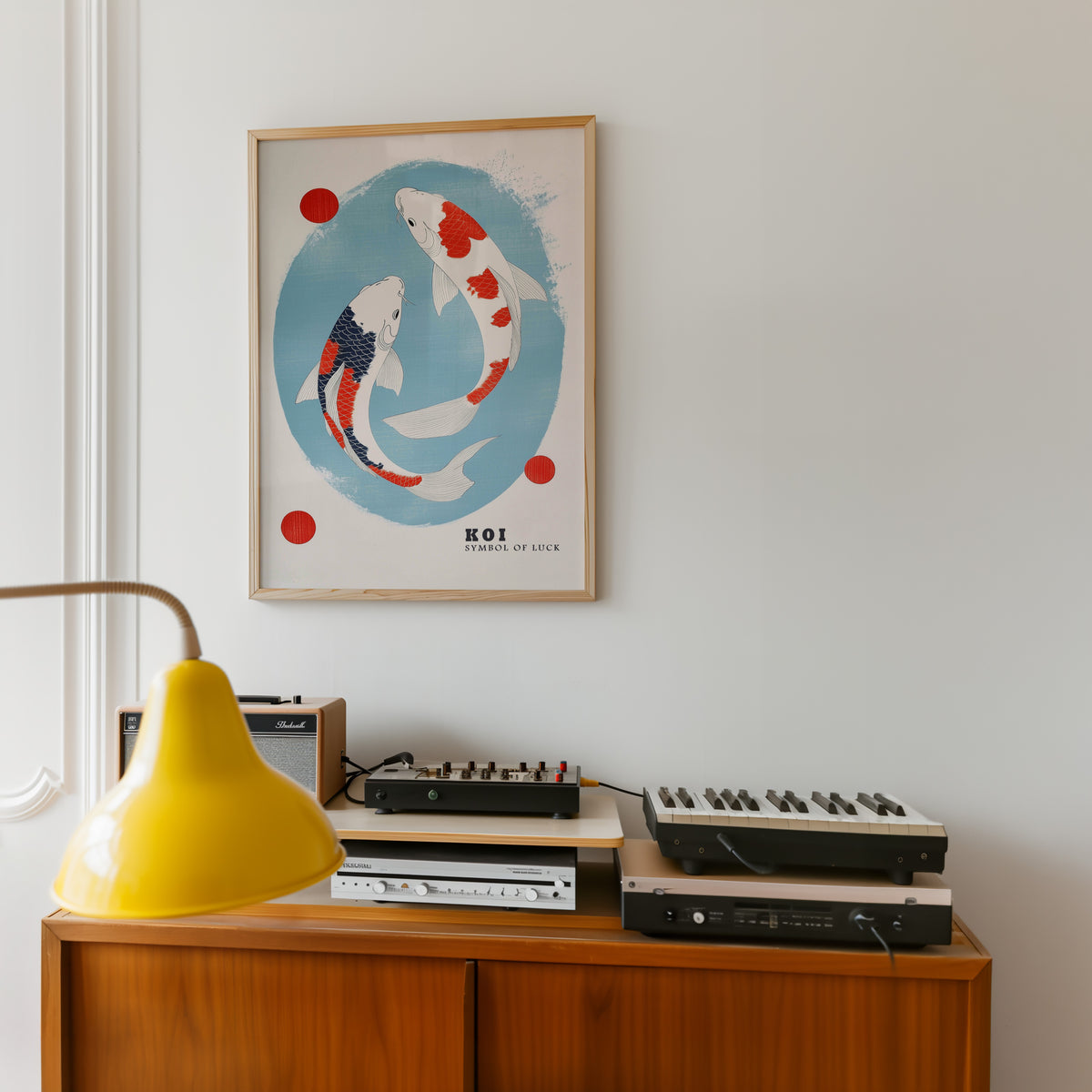 Two koi circling in blue oval print in an oak frame above a teak sideboard with vintage hi-fi
