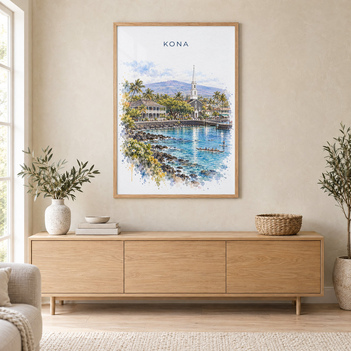 Kona, Hawaii watercolor print in an oak frame above a light wood sideboard in a Scandinavian living room