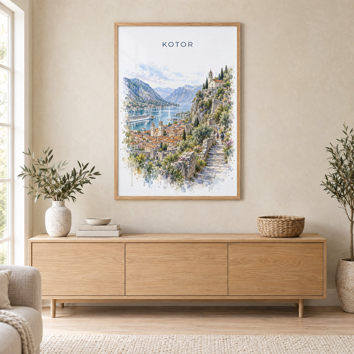 Kotor watercolor print in an oak frame above a light wood sideboard in a Scandinavian living room