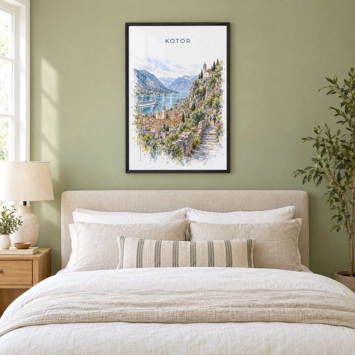 Kotor watercolor print in a black frame above an upholstered headboard in a sage green bedroom