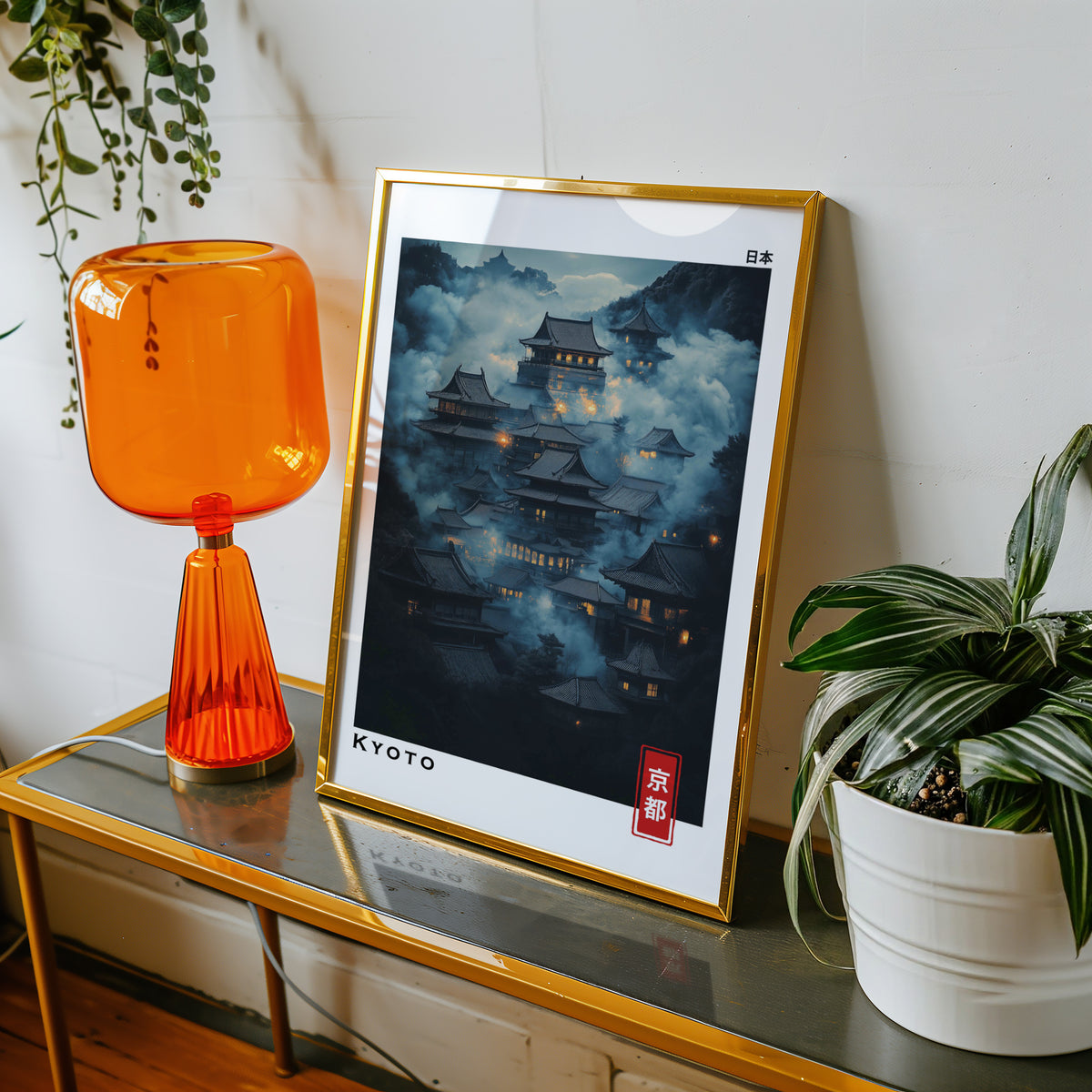 Kyoto misty night temples print shown in a gold frame on a console beside an orange glass lamp