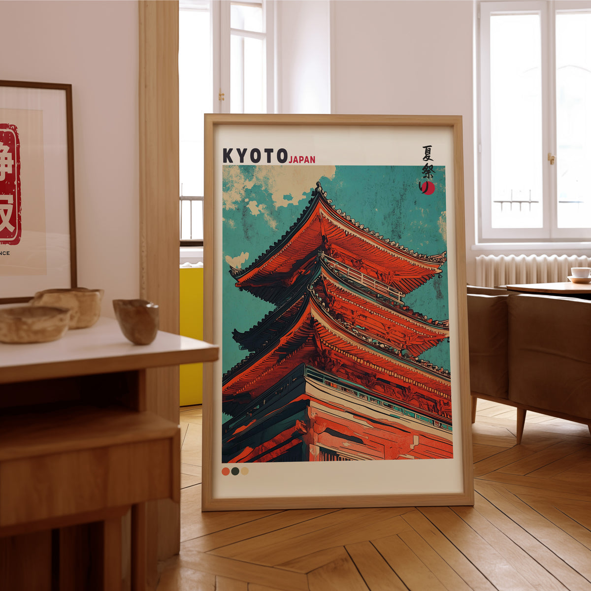 Red pagoda roofs under teal sky print in an oak frame on the parquet floor of a sunlit living room