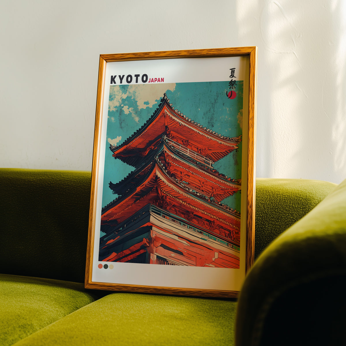 Red pagoda roofs under teal sky print in an oak frame propped on a green velvet sofa