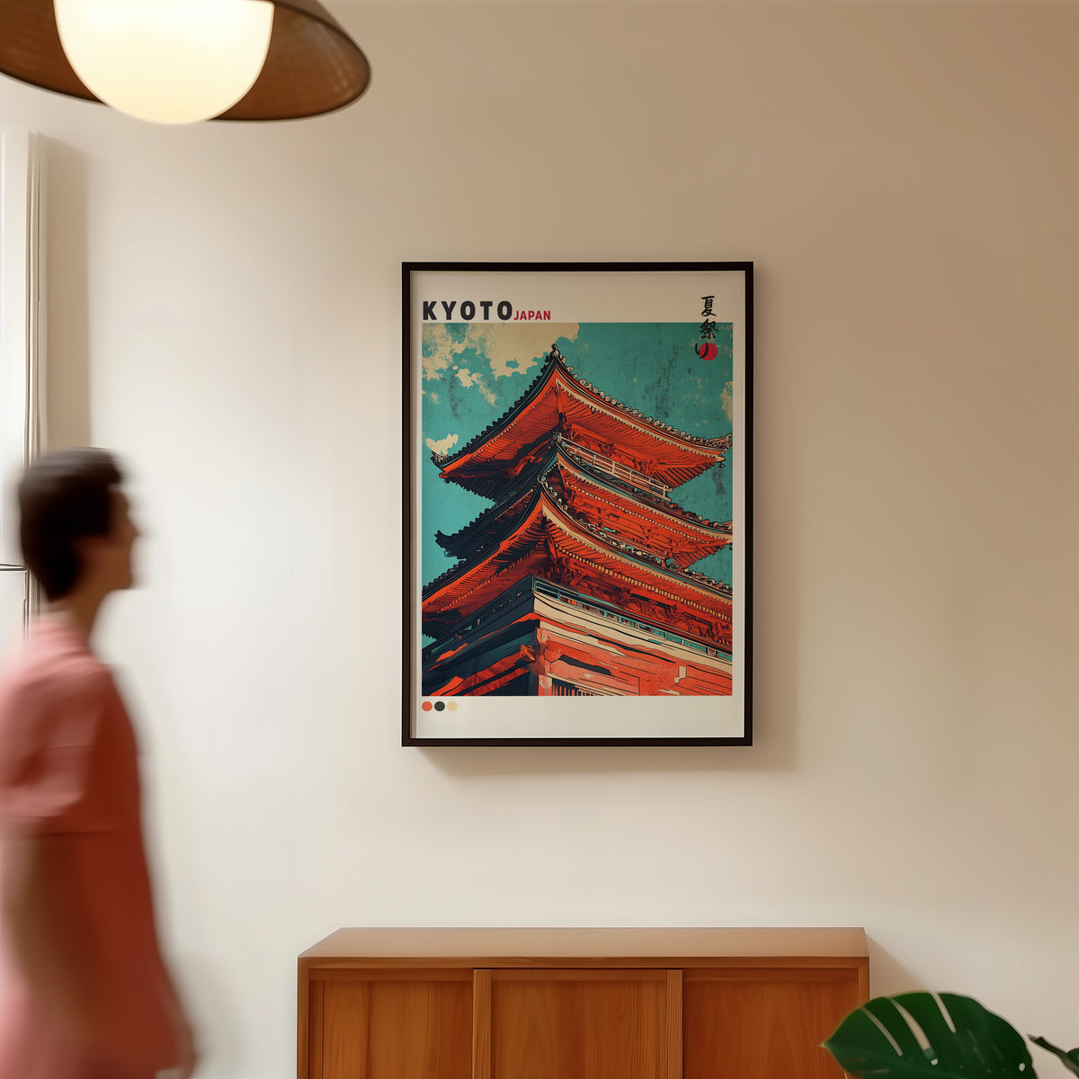 Red pagoda roofs under teal sky print in a black frame in a hallway under a rattan pendant