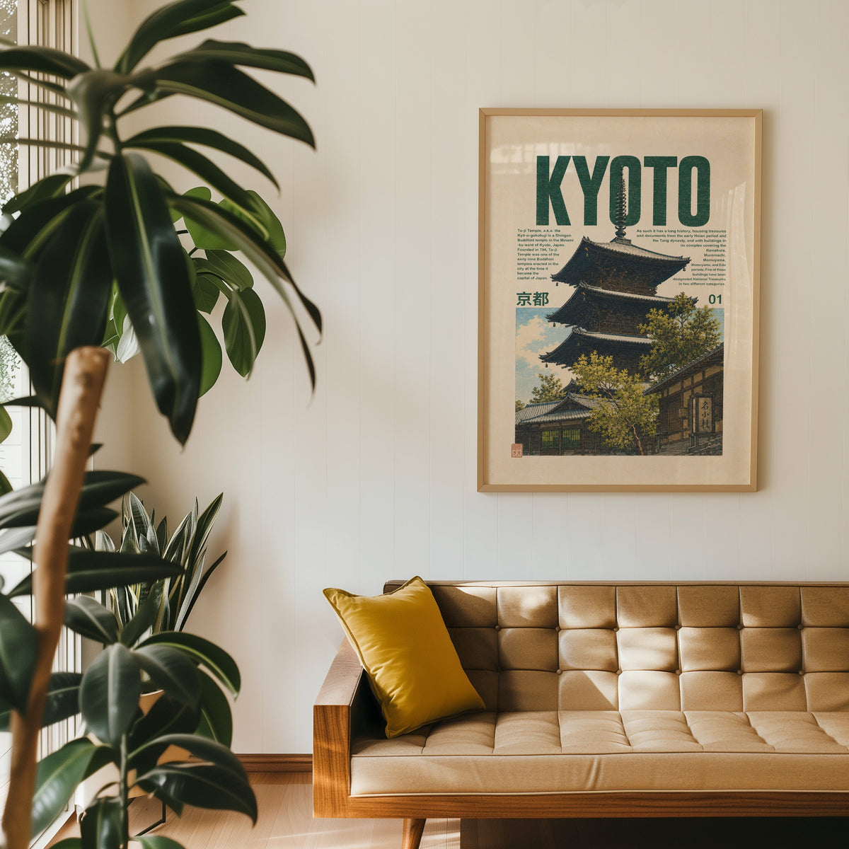 Kyoto pagoda travel poster print in an oak frame above a tan tufted leather sofa with a mustard cushion