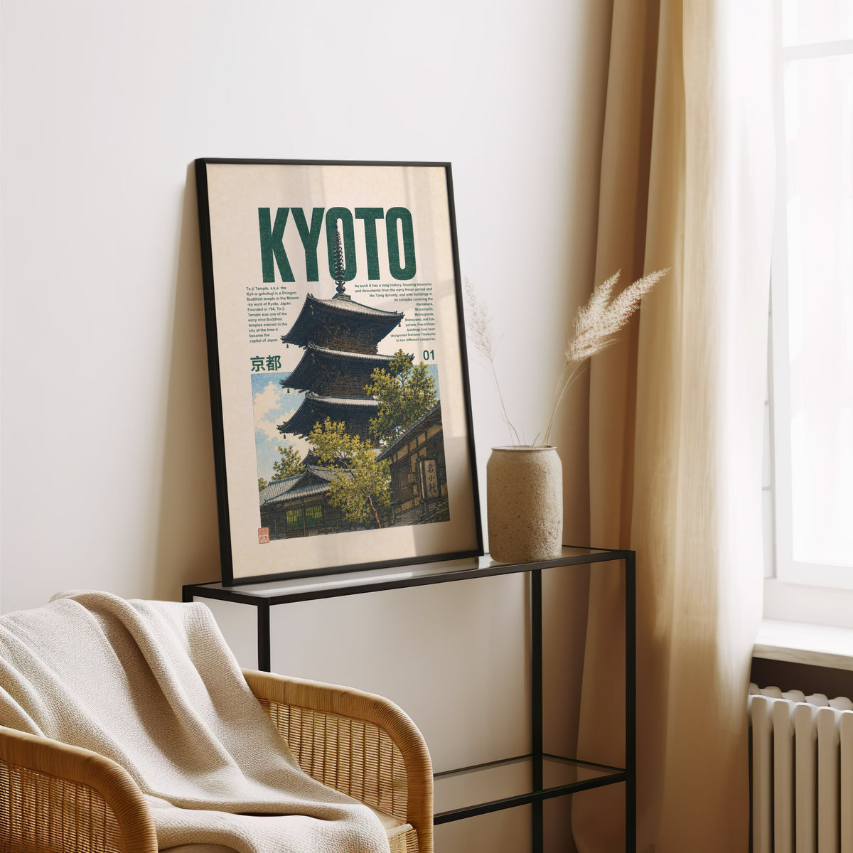 Kyoto pagoda travel poster print in a black frame leaning on a glass console beside pampas grass