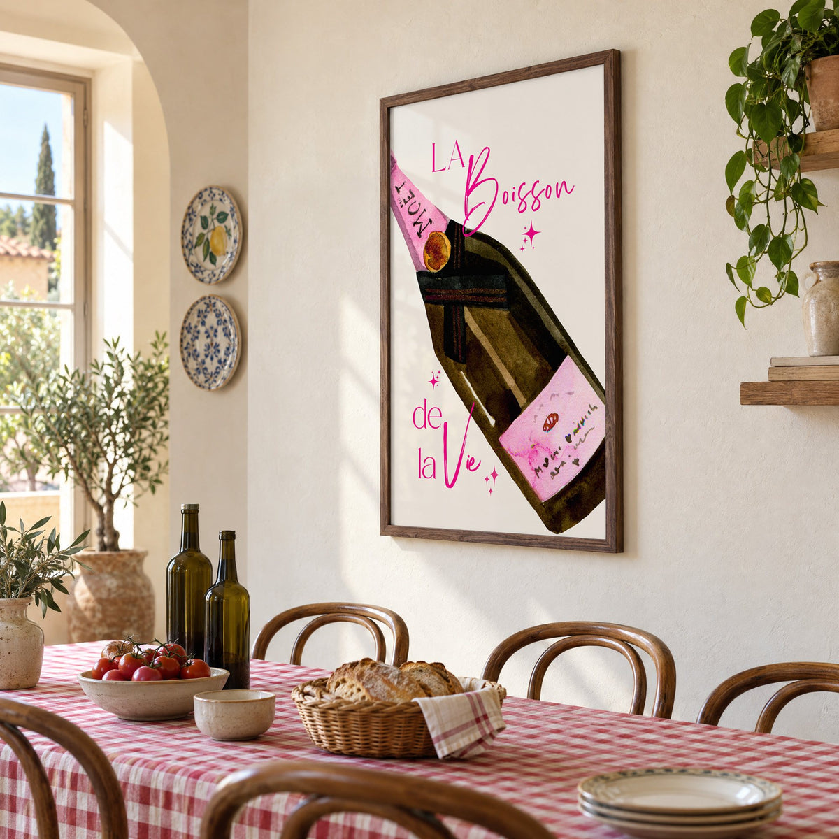 La Boisson champagne bottle watercolor print in a walnut frame above a gingham-covered trattoria table, seen at an angle