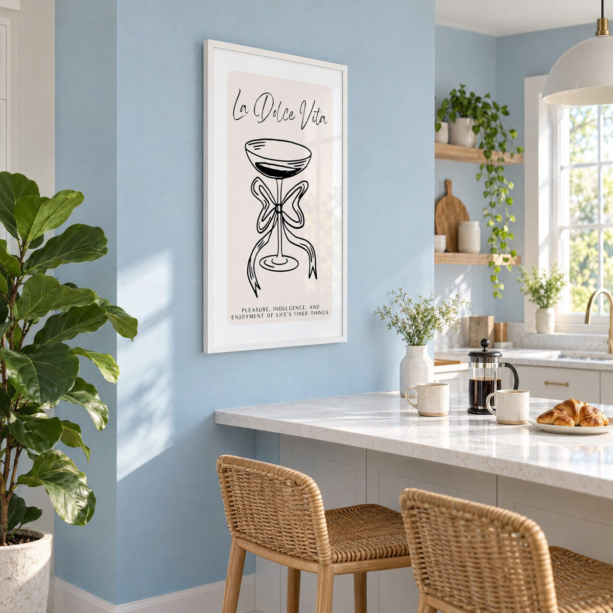 La Dolce Vita black line coupe print in a white frame on a pale blue wall above a breakfast bar with rattan stools