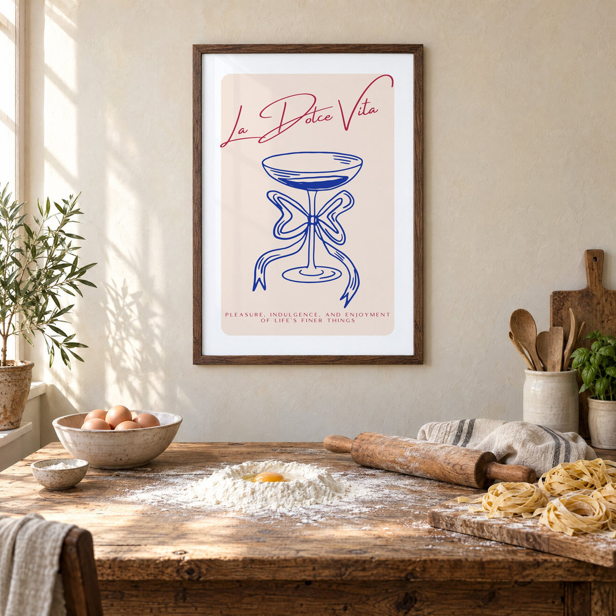 La Dolce Vita cobalt coupe print in a walnut frame above a rustic table set for making fresh pasta