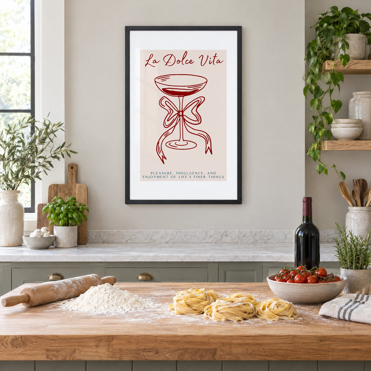 La Dolce Vita coupe bow line print in a black frame above a butcher-block island with fresh pasta, flour and cherry tomatoes