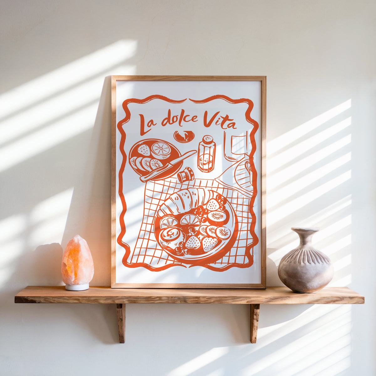 La Dolce Vita table print in an oak frame on a live-edge shelf beside a salt lamp