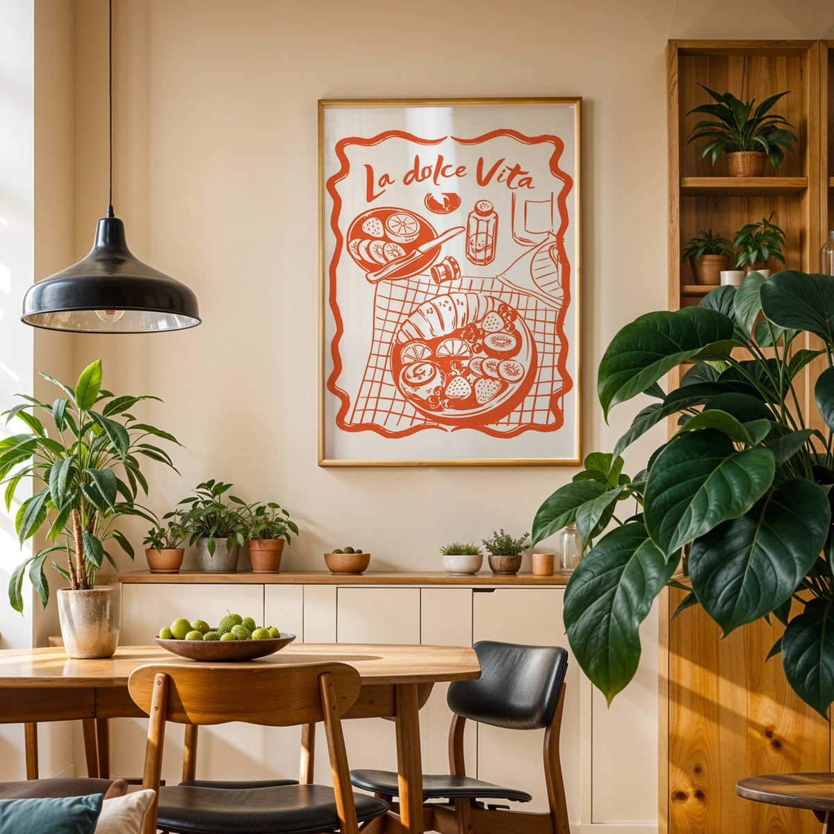 La Dolce Vita table print in an oak frame in a dining room above a plant-lined sideboard