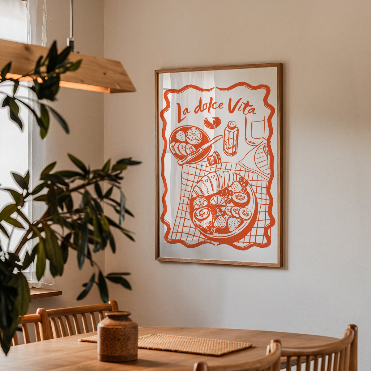 La Dolce Vita table print in a walnut frame above a dining table with olive branches