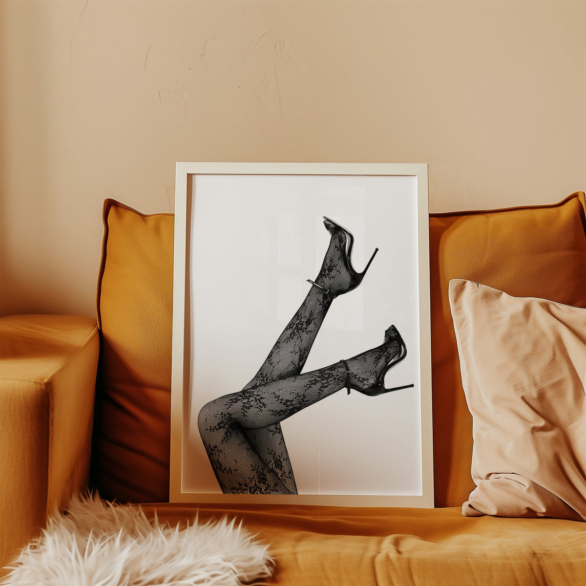 Legs in floral lace tights and stilettos print in a white frame leaning on a mustard velvet sofa
