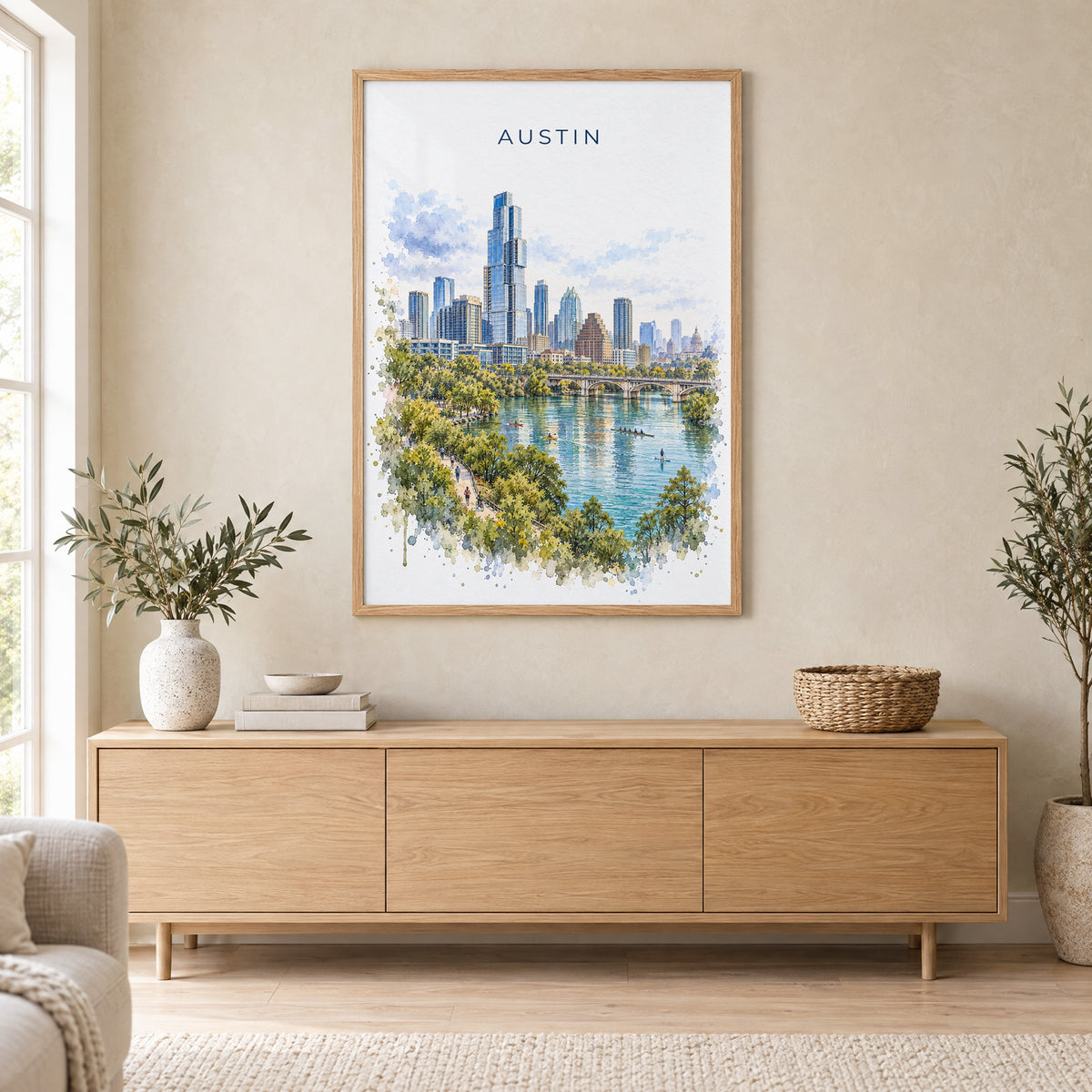 Lady Bird Lake Austin watercolor print in an oak frame above a light wood sideboard in a Scandinavian living room