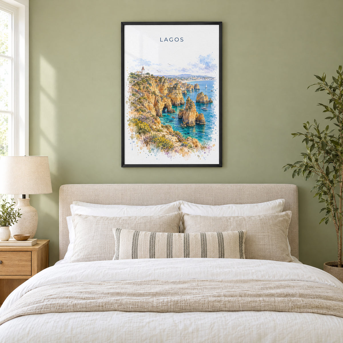 Lagos, Portugal watercolor print in a black frame above an upholstered headboard in a sage green bedroom