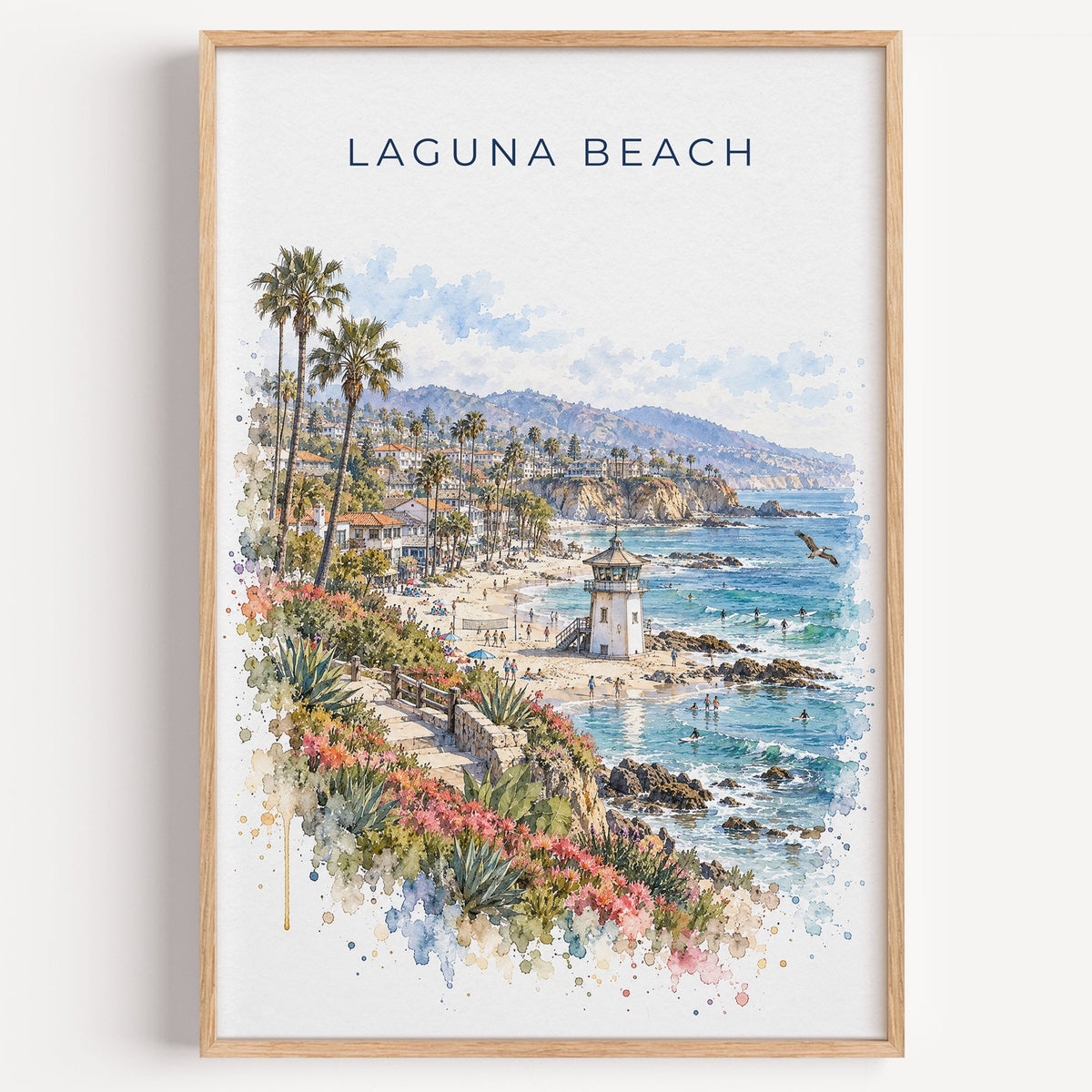 Laguna Beach watercolor print in a light oak frame on a plain white wall