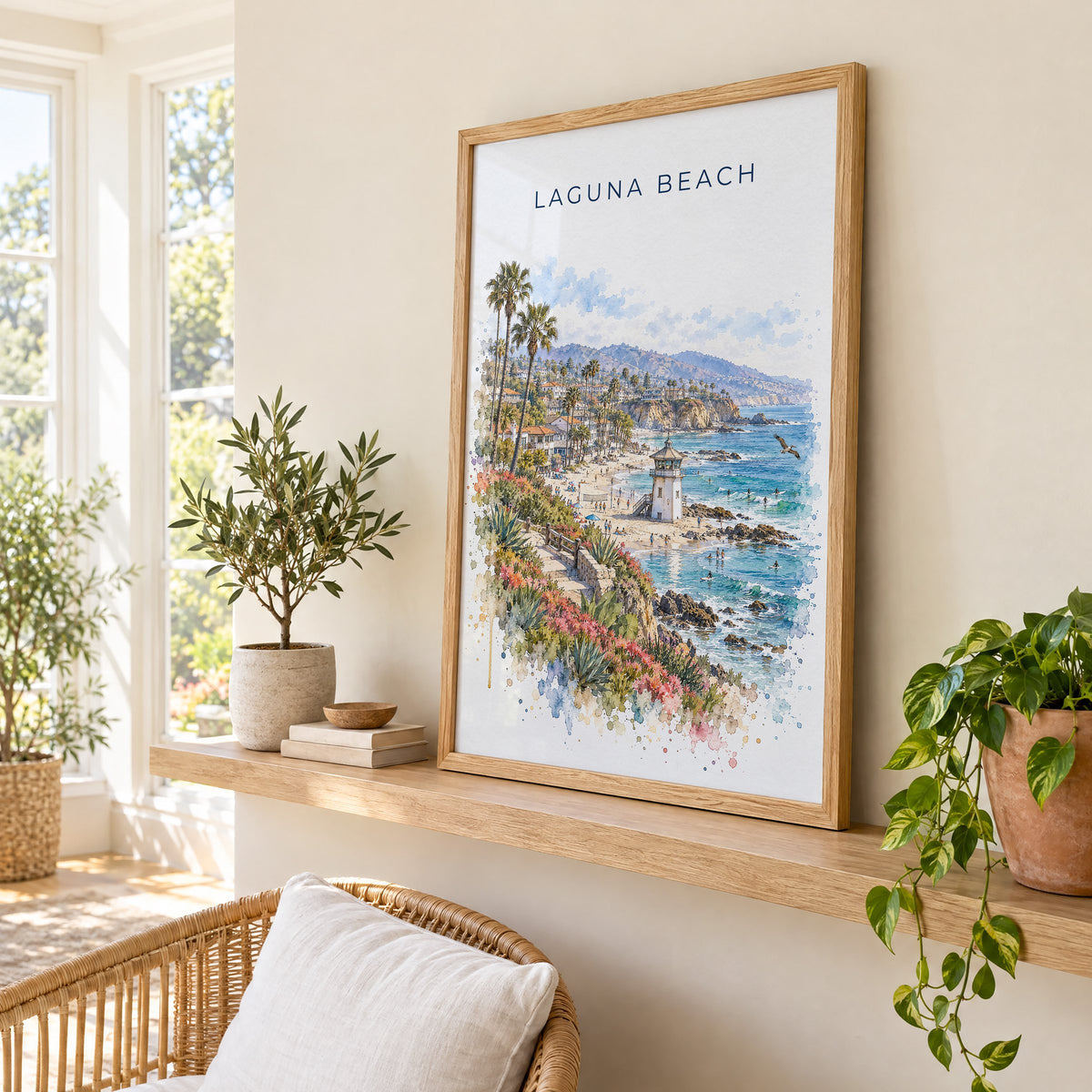 Laguna Beach watercolor print in an oak frame on a picture ledge in a sunlit sunroom