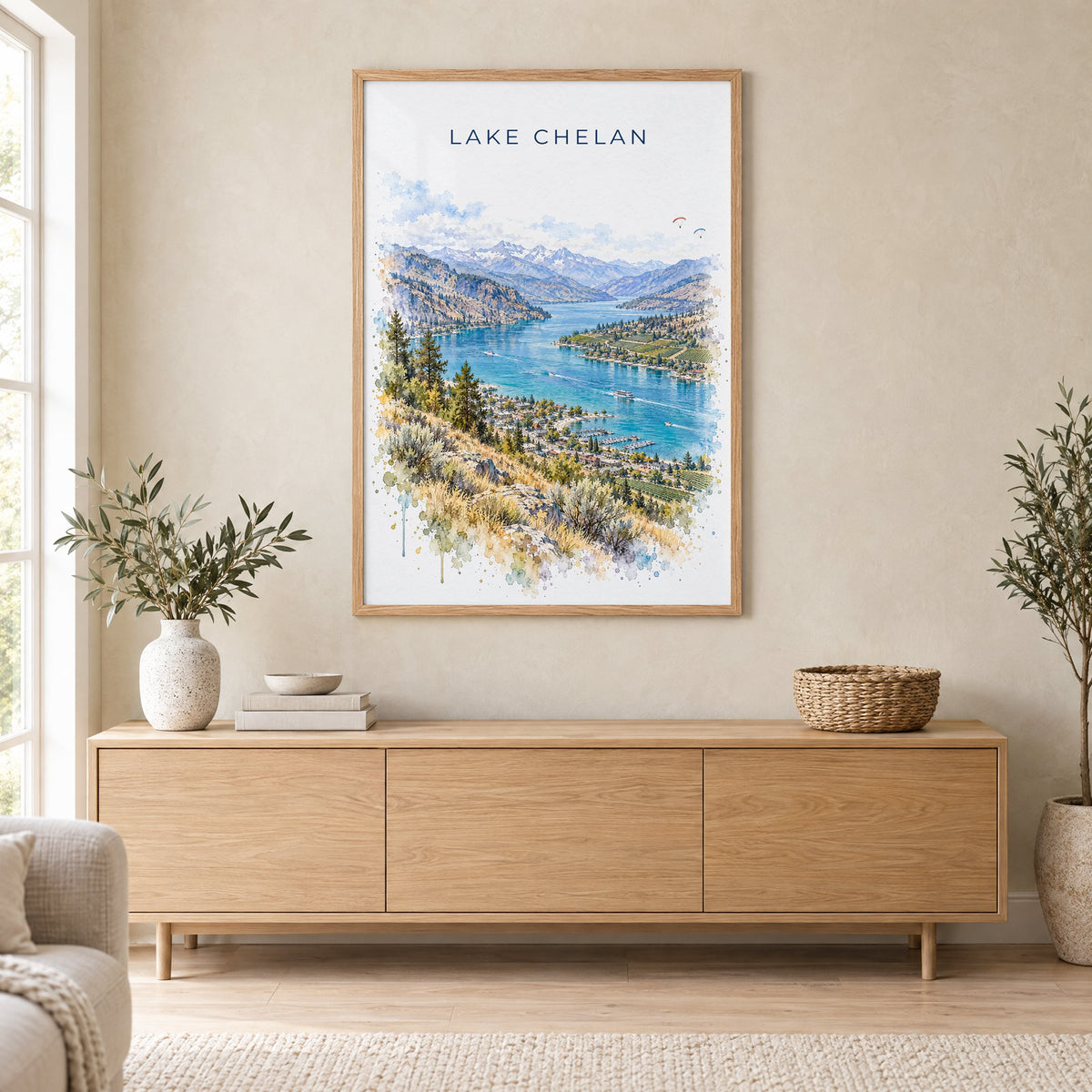 Lake Chelan watercolor print in an oak frame above a light wood sideboard in a Scandinavian living room