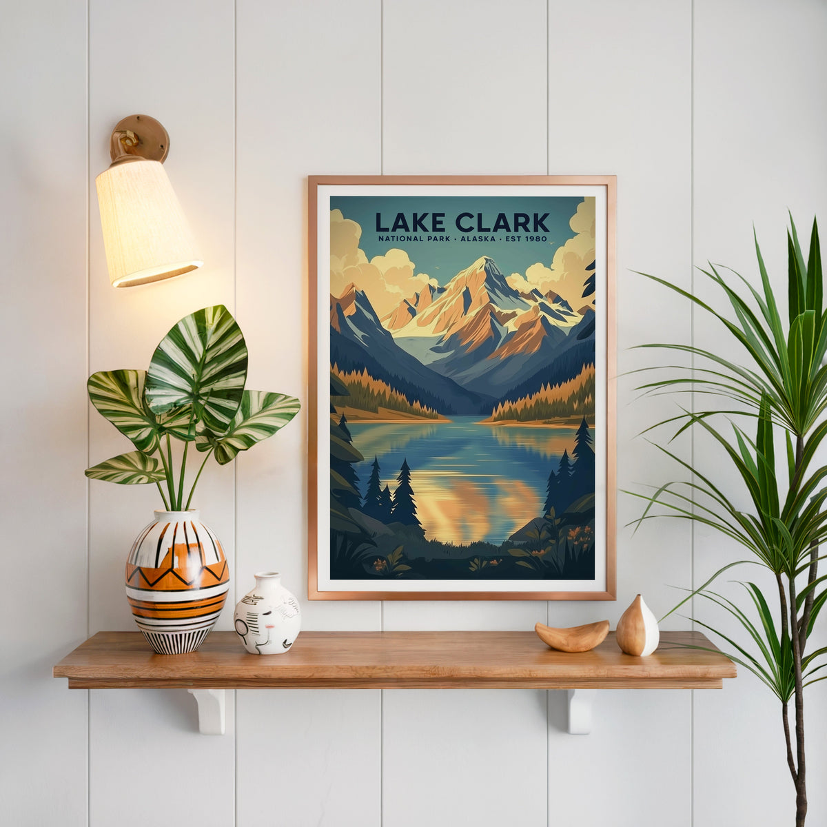 Lake Clark National Park print in a copper frame above an oak shelf on white shiplap with a brass sconce