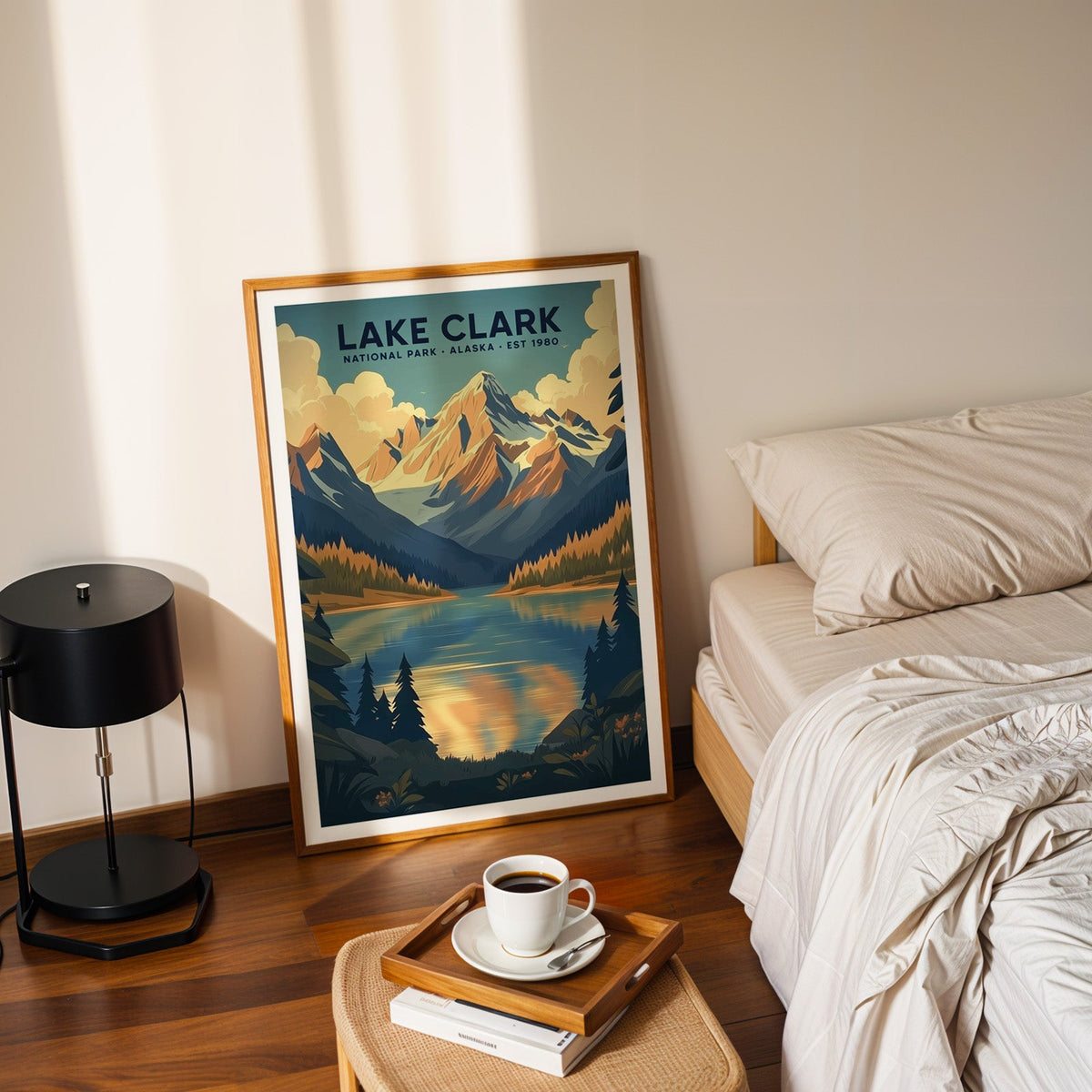 Lake Clark National Park print in an oak frame leaning on a bedroom floor beside the bed and a coffee tray