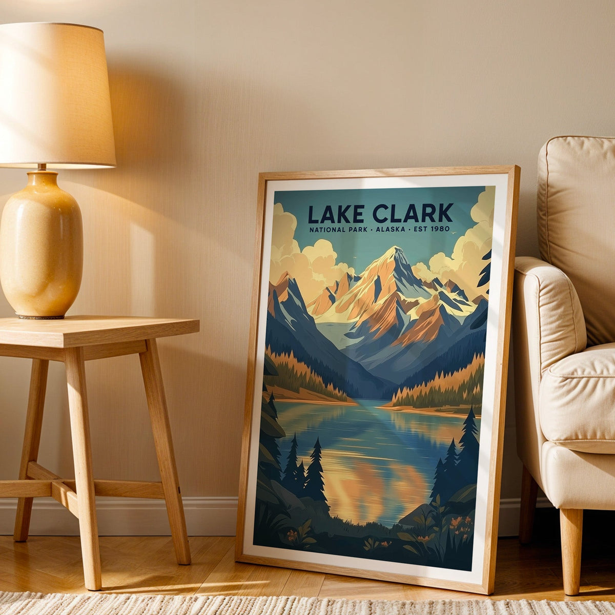 Lake Clark print in an oak frame beside a cream armchair and an amber lamp in warm afternoon light
