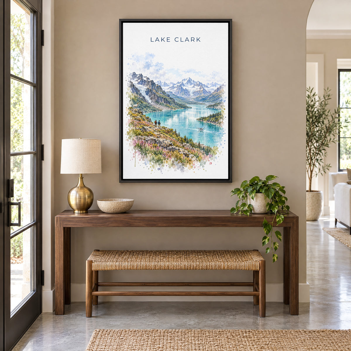 Lake Clark National Park watercolor print as a black floater canvas above a walnut console and woven bench in an entryway