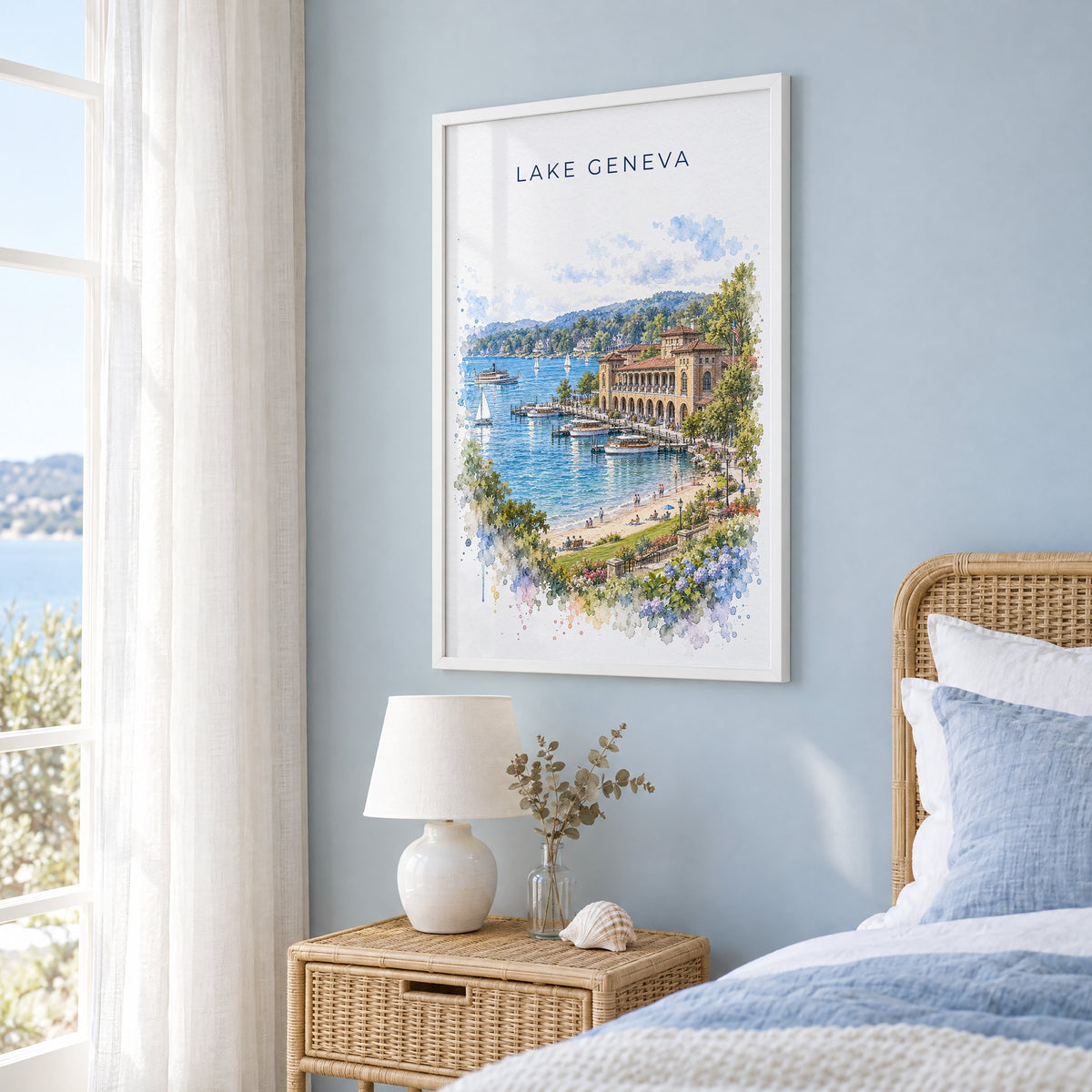Lake Geneva, Wisconsin watercolor print in a white frame on a pale blue wall beside a rattan bed in a coastal bedroom