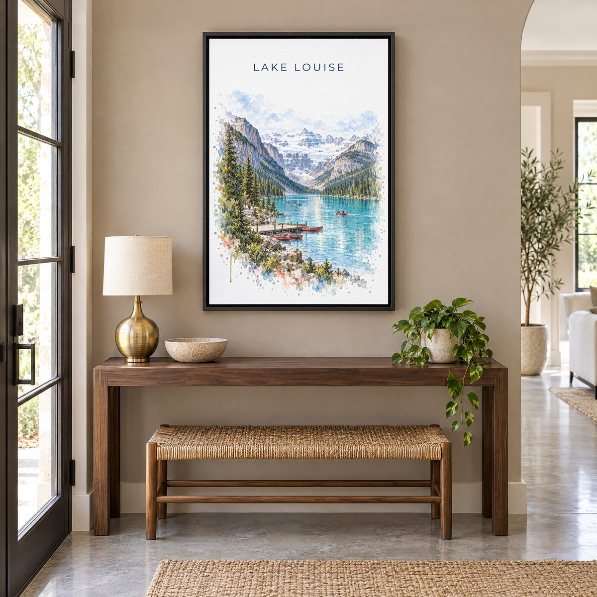 Lake Louise watercolor print as a black floater canvas above a walnut console and woven bench in an entryway