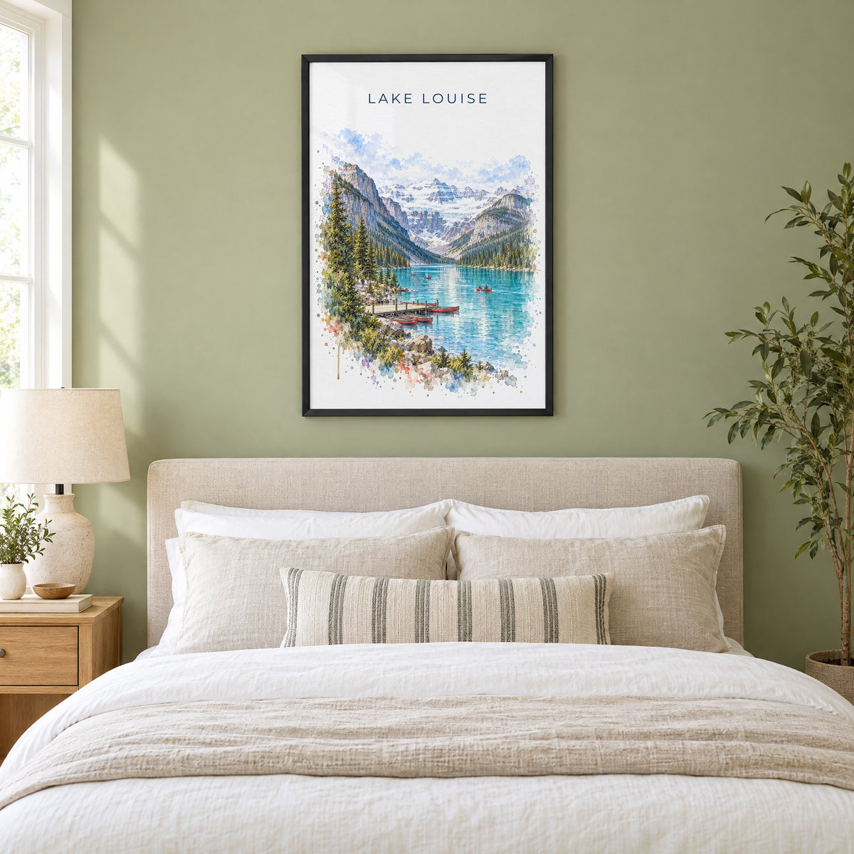 Lake Louise watercolor print in a black frame above an upholstered headboard in a sage green bedroom