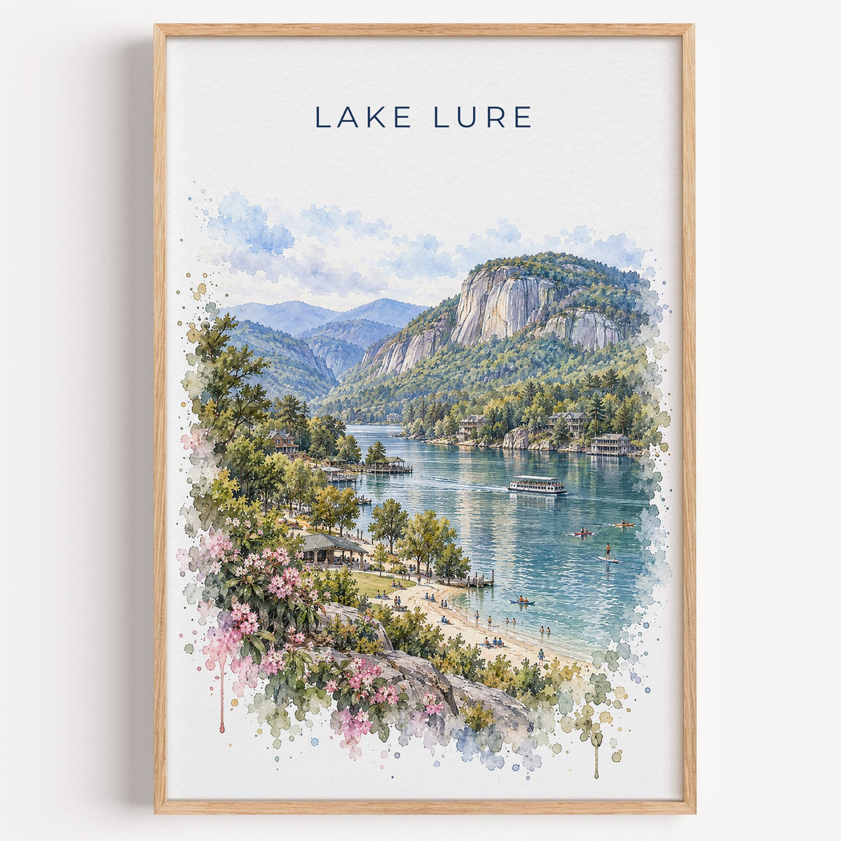 Lake Lure watercolor print in a light oak frame on a plain white wall