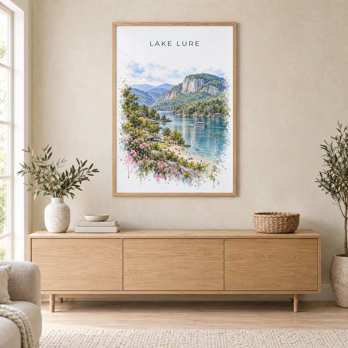Lake Lure watercolor print in an oak frame above a light wood sideboard in a Scandinavian living room