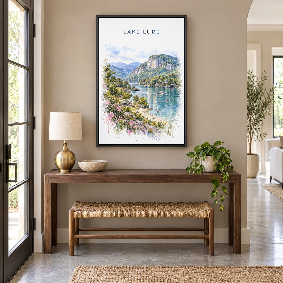 Lake Lure watercolor print as a black floater canvas above a walnut console and woven bench in an entryway