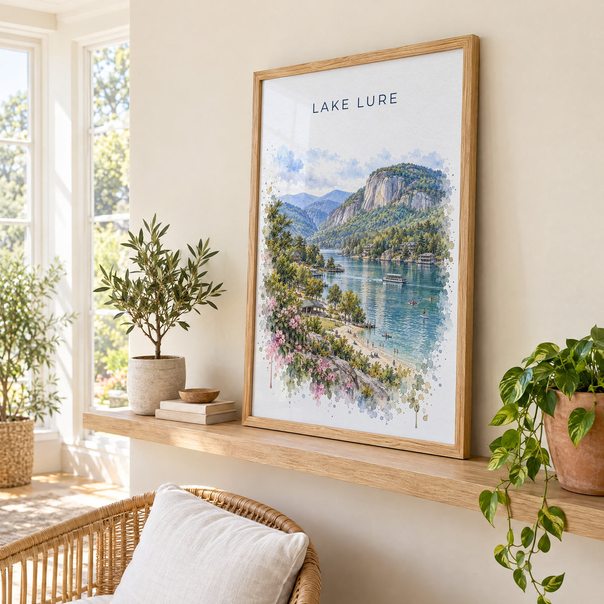 Lake Lure watercolor print in an oak frame on a picture ledge in a sunlit sunroom