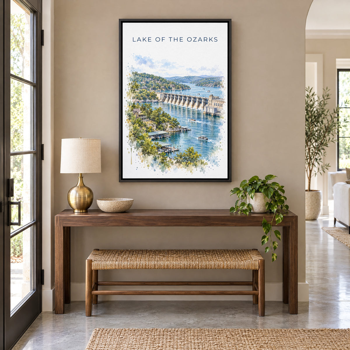 Lake of the Ozarks watercolor print as a black floater canvas above a walnut console and woven bench in an entryway