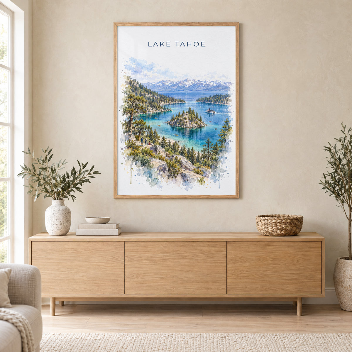Lake Tahoe watercolor print in an oak frame above a light wood sideboard in a Scandinavian living room