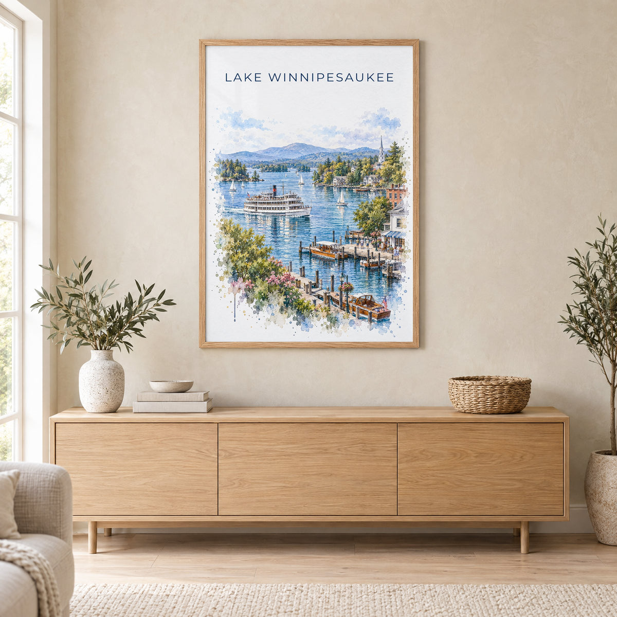 Lake Winnipesaukee watercolor print in an oak frame above a light wood sideboard in a Scandinavian living room