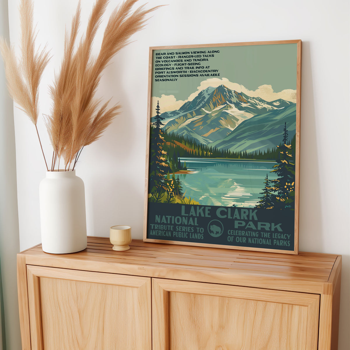 Lake Clark National Park wall art leaning on an oak sideboard with pampas grass in a vase