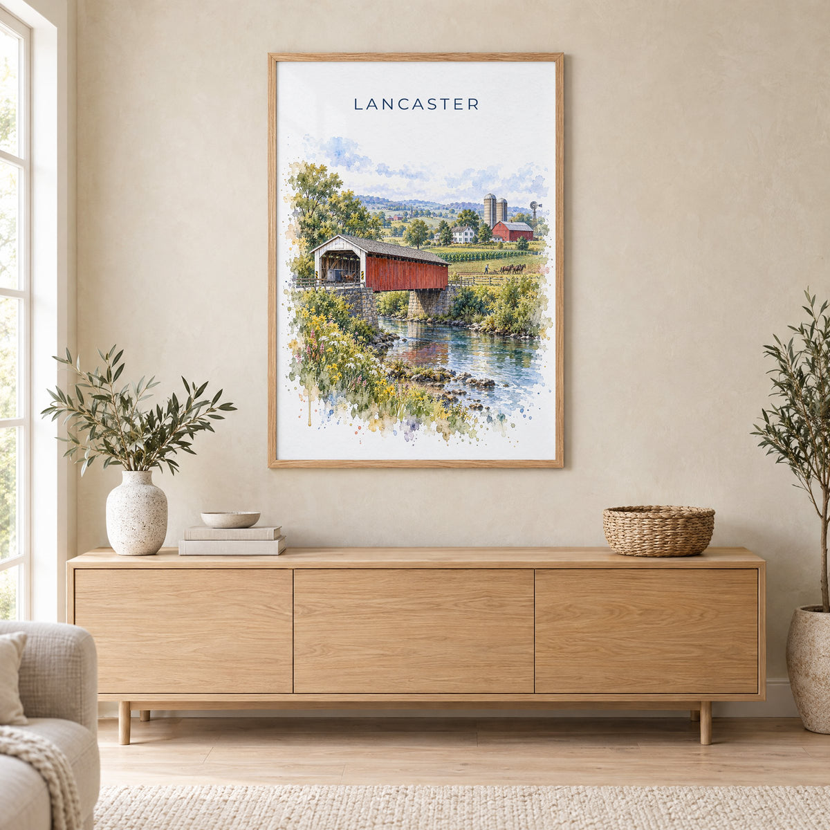 Lancaster, Pennsylvania watercolor print in an oak frame above a light wood sideboard in a Scandinavian living room