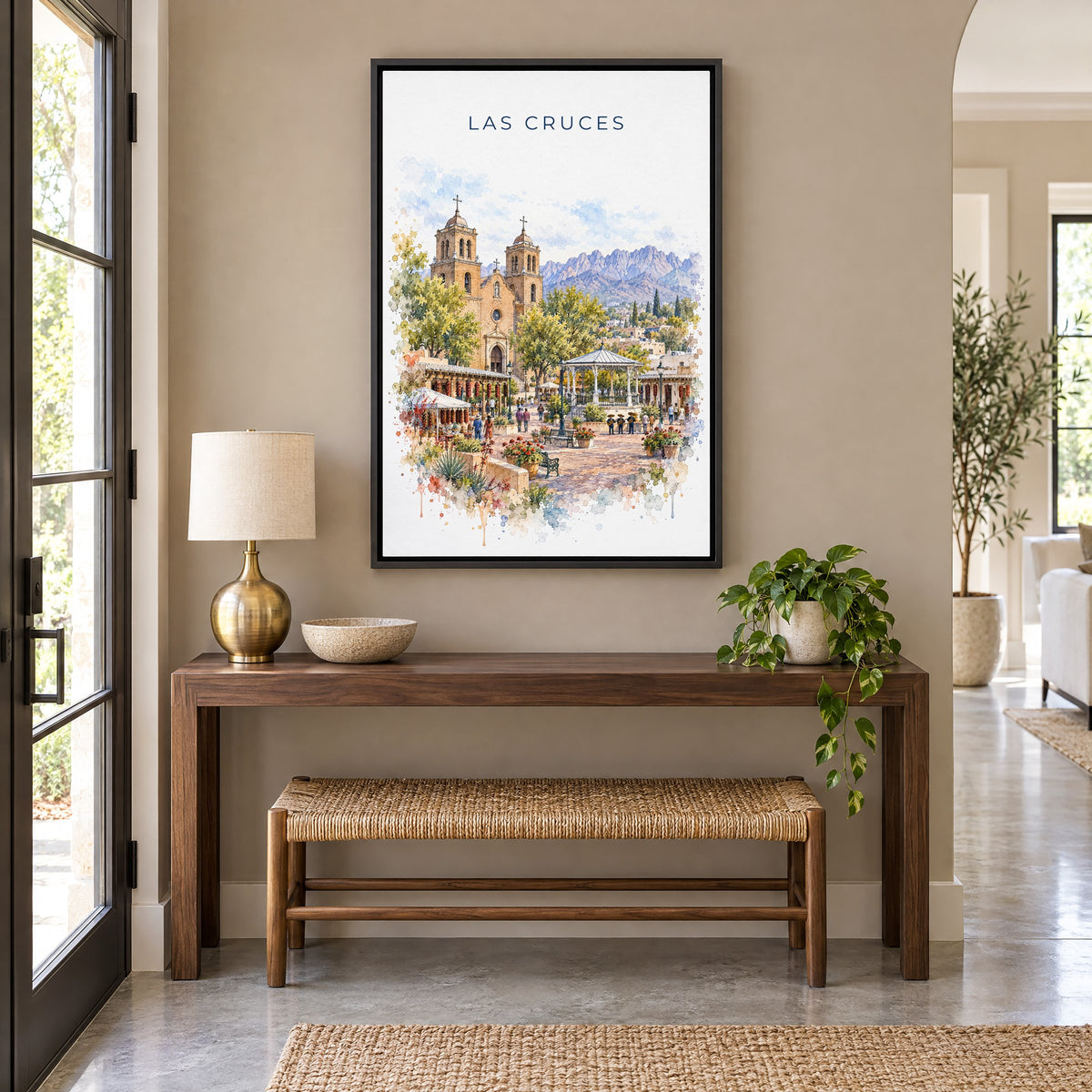 Las Cruces watercolor print as a black floater canvas above a walnut console and woven bench in an entryway