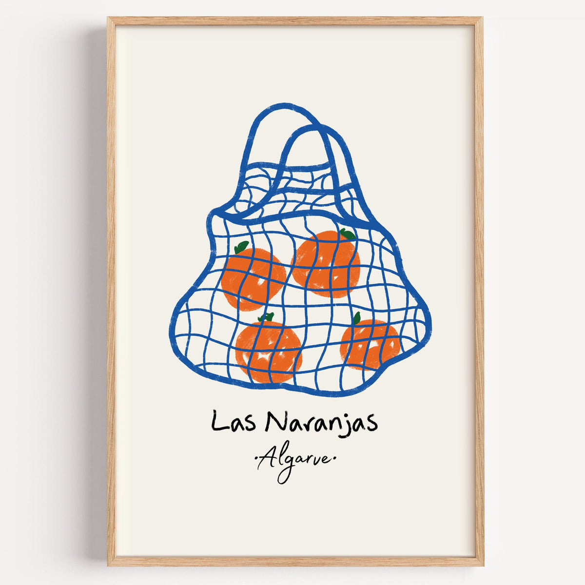 Las naranjas orange net bag print in a light oak frame on a plain white wall