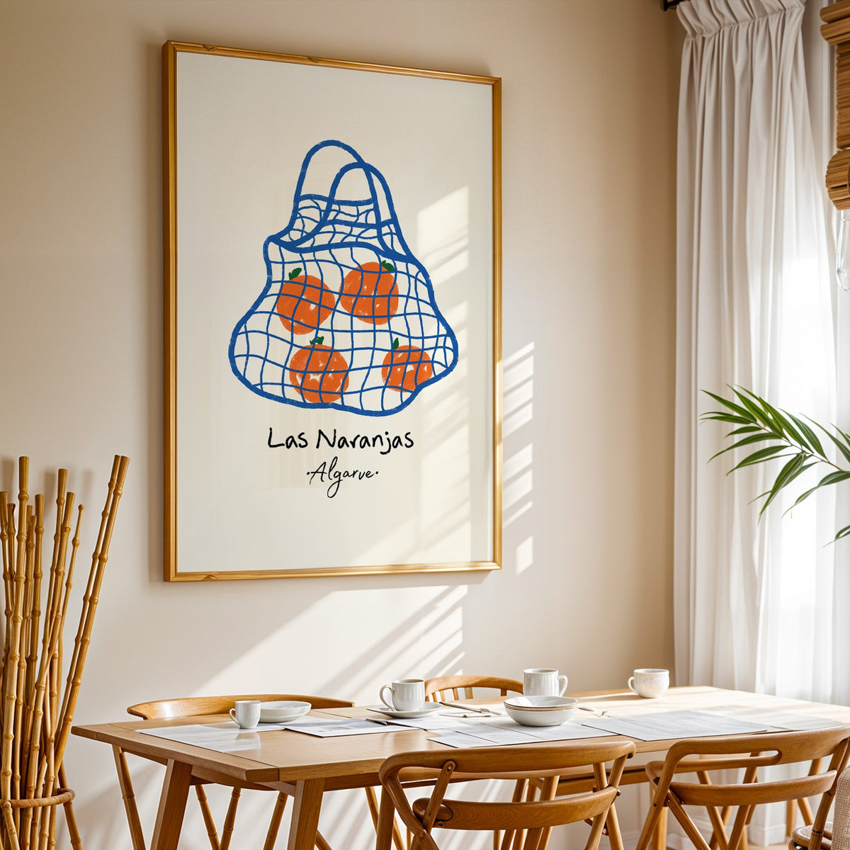 Las naranjas orange net bag print in a gold frame above a sunlit breakfast table