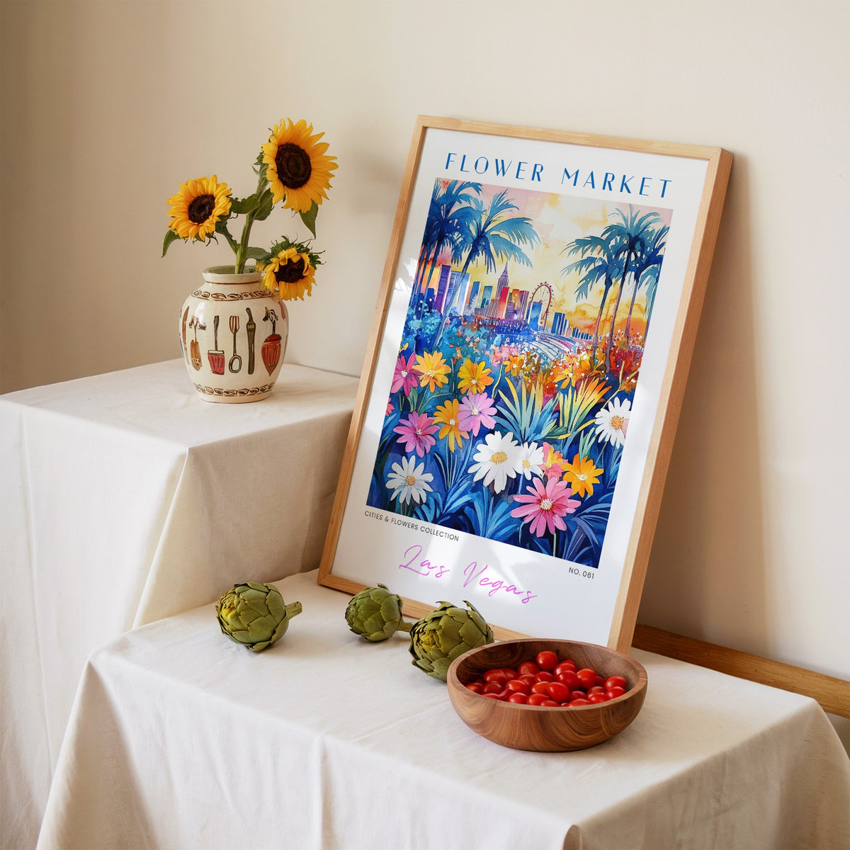 Las Vegas flower market print in an oak frame leaning on a linen-draped table beside a vase of sunflowers