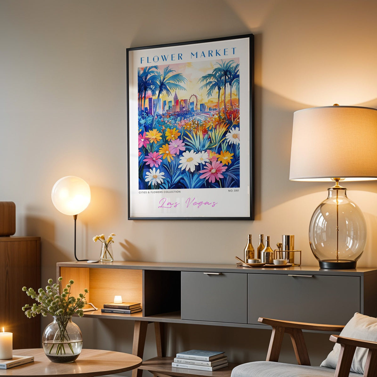 Las Vegas flower market print in a black frame above a grey media console with a glass table lamp