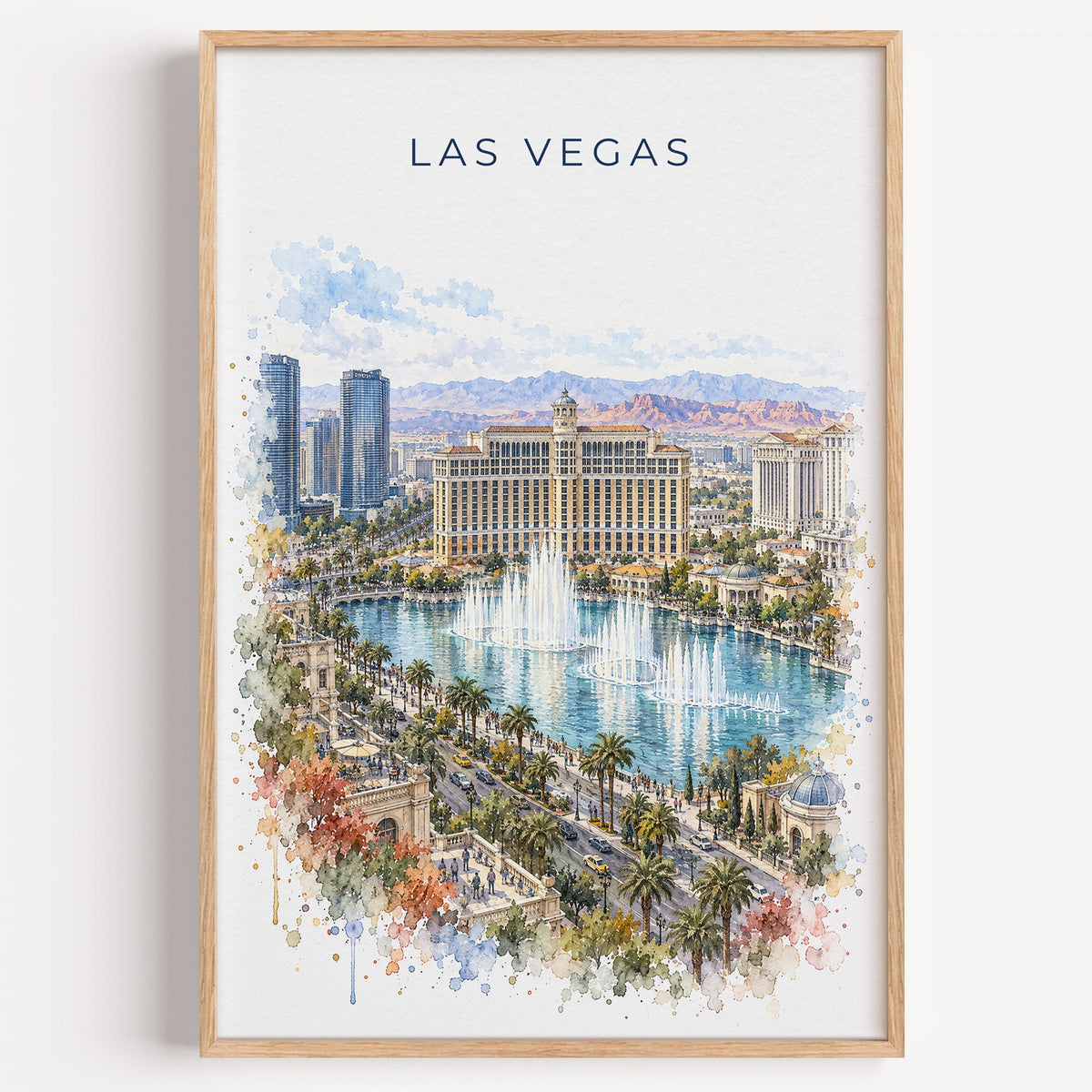 Las Vegas watercolor print in a light oak frame on a plain white wall